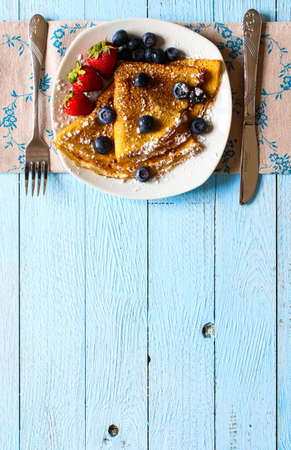 Delicious Crepes Breakfast with Dramatic light over a vintage wood background. An healthy meal of...