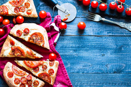 Tasty Hand Made Tomatoes  Pizza Bread with italian style recipe over a wooden table with a Dramatic light.の写真素材