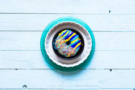 Colorful Donuts breakfast composition with different color styles of doughnuts over an aged wooden...
