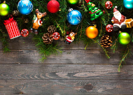 Merry Christmas Frame with real wood green pine, colorful baubles, gift boxe and other seasonal stuff over an old wooden aged backgroundの写真素材