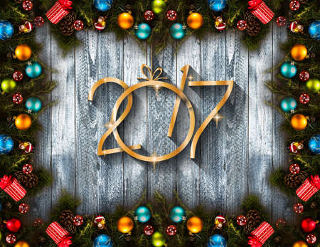 2017 Happy New Year seasonal background with real wood green pine, colorful Christmas baubles, gift boxe and other seasonal stuff over an old wooden aged backgroundの写真素材