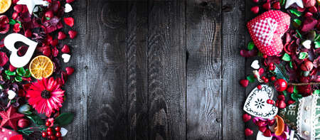 Valentine's Day Background with love themed elements like cotton and paper hearts, flowers, berries, oranges and other decorations. Wooden old parquet on the back.の写真素材