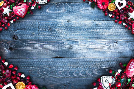 Valentine's Day Background with love themed elements like cotton and paper hearts, flowers, berries, oranges and other decorations. Wooden old parquet on the back.の写真素材