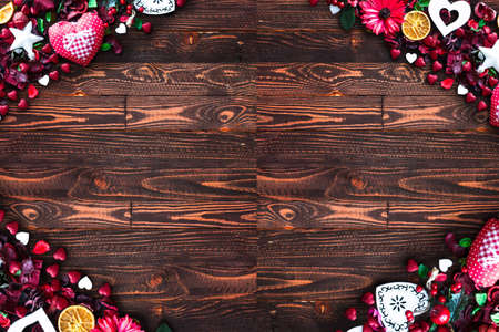 Valentine's Day Background with love themed elements like cotton and paper hearts, flowers, berries, oranges and other decorations. Wooden old parquet on the back.の写真素材