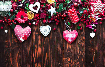 Valentine's Day Background with love themed elements like cotton and paper hearts, flowers, berries, oranges and other decorations. Wooden old parquet on the back.の写真素材