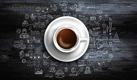 Infograph background template with a fresh coffee on real wooden table with infographic design elements and mockups and hand drawn sketches of technology items.の写真素材