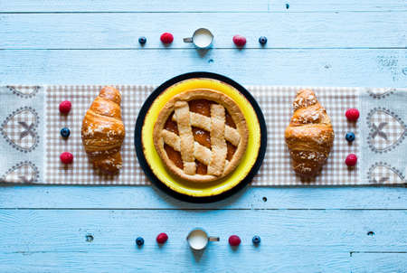 Top view of a wood table full of cakes, fruits, coffee, biscuits, spices and more breakfast classic sweet foods.の写真素材