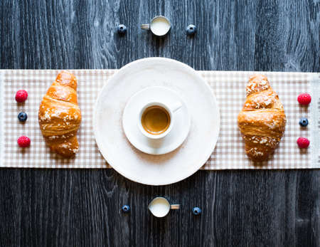 Top view of a wood table full of cakes, fruits, coffee, biscuits, spices and more breakfast classic...
