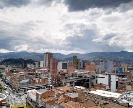 Panoramic view of the city center of Medellin (downtown), Colombia, with commercial buildings, elevated metro station (San Antonio), streets crowded with cars and background of the typical mountainsのeditorial素材