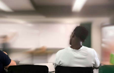 African-American student paying attention to a class in a school or university classroom. Blurred effect and copyspace.のeditorial素材