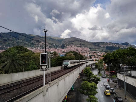 View of the Medellin Metro, Colombia. Elevated train over the city, mass public transport. View of the mountains and buildings of this Colombian city.のeditorial素材
