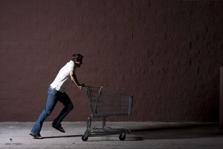 Yount white male with a shopping cartの写真素材