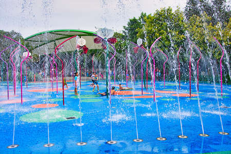 Children are playing and enjoying themselves at the floor fountain in Singapore.のeditorial素材