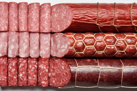 Three types of smoked sausages, sticks and slicesの写真素材