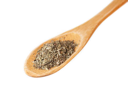 Wooden spoon with dried basil isolated on white backgroundの写真素材