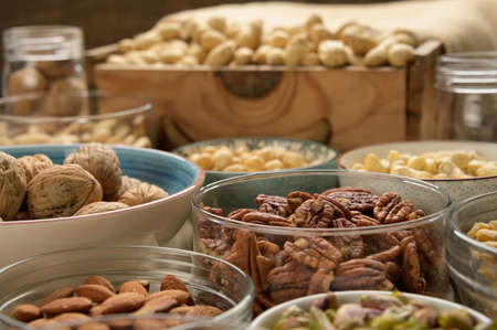 Different nuts closeup on a wooden table and brown background