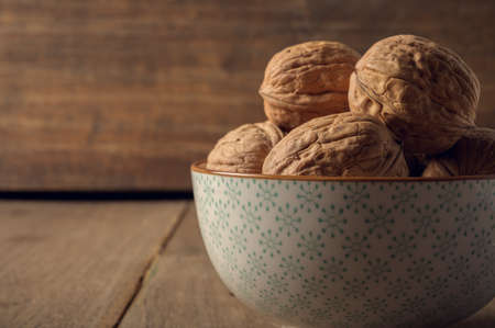 Walnuts in a ceramic bowl on a dark background.の写真素材