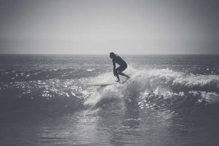 SURFING TAKING A WAVEの写真素材