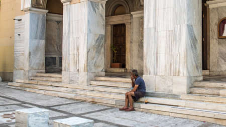 Athens Greece/August 17, 2018: Woman walking down closed down flea market with graffiti on the closed doorsのeditorial素材