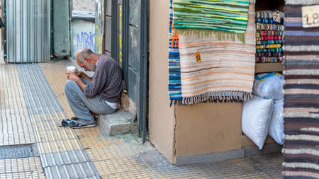 Athens Greece/August 17, 2018: Woman walking down closed down flea market with graffiti on the closed doorsのeditorial素材