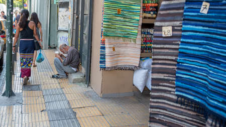 Athens Greece/August 17, 2018: Woman walking down closed down flea market with graffiti on the closed doorsのeditorial素材