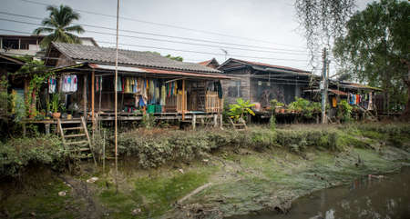 Houses on canal at low tide in Thailandの写真素材