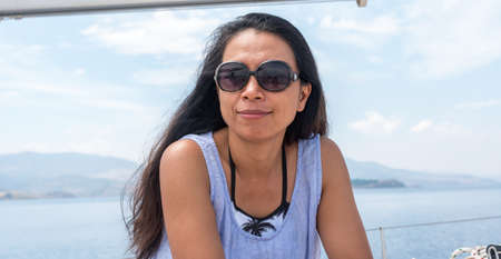 woman with sunglasses on sailboat looking at photographer