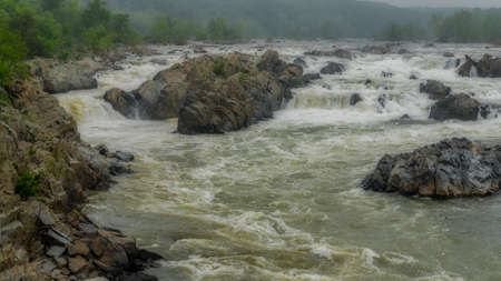 Rushing water at Great Falls National Park on a stormy overcast dayの写真素材