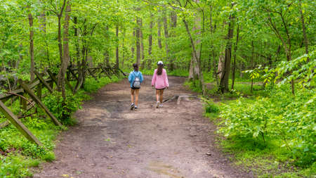 Mother with pink sweater and teen daughter walking down path in Great Falls national Park, Virginiaの写真素材