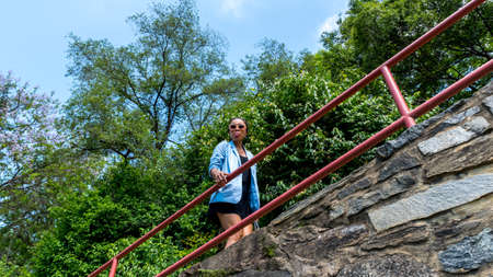 Asian woman walking down path and sticking out tongue on bridge along the Chesapeake and Ohio Canal