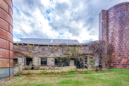 Abandoned barn with silo under stormy clouds in Alamance County North Carolinaの写真素材