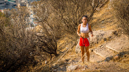 Teen in red shorts running on trail on mountain in Athens Greeceの写真素材