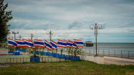 Many flags on poles in a seaside park in Prak nam pran Thailand