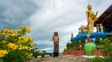 Woman standing in garden in wat in Pak Nam pran surrounded by flowersの写真素材