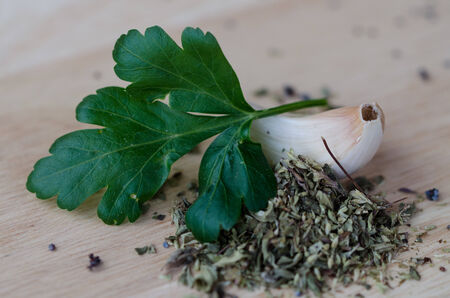 Garlic on the table with oregano and parsleyの写真素材