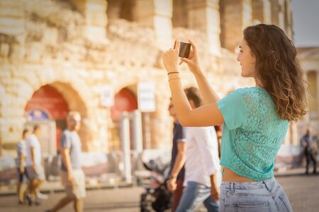 Girl tourist on vacation in Verona taking pictures, Italy,の写真素材