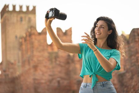 Girl taking a selfie with a big camera, old technologyの写真素材