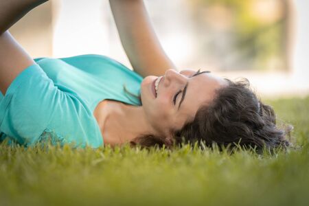 Photographer girl lying on the grass happy and smiling, relaxingの写真素材