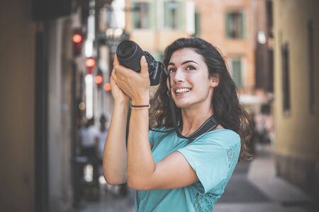 Girl tourist or professional photographer who shoots in a typical Italian city.の写真素材