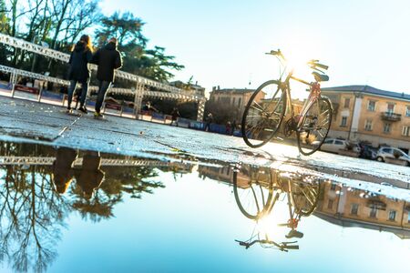 Bicycle reflected in the water in Verona, Piazza San Zeno, in the back there ti the curchの写真素材