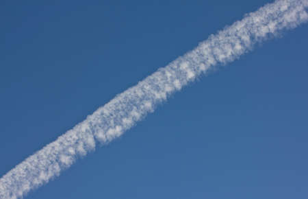 This trail flying plane formed by the products of fuel combustion engines.
