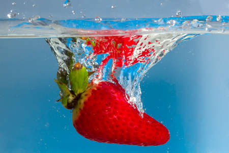 Strawberry splash with blue backgroundの写真素材