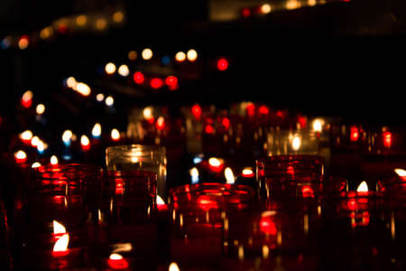 Red candels on a dark background in a churchの写真素材