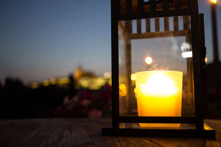 Panoramic view and closeup of candle on a table in a romatic restaurantの写真素材