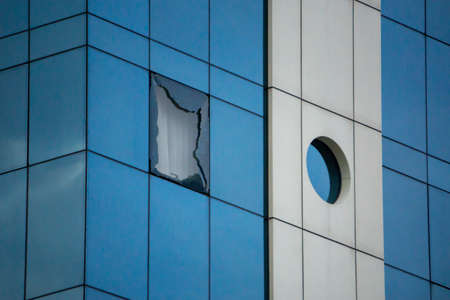 A broken window in an office building. Expresses anger, depression, stress related to work