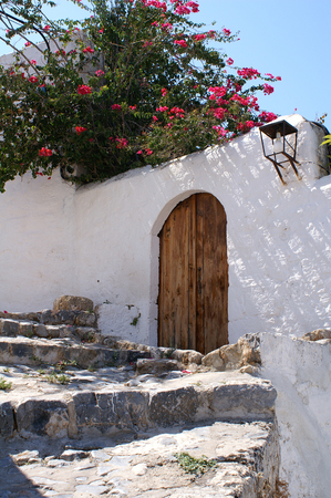 Old wooden door in a whitewashed wall in Lindos, Rhodes, Greeceの写真素材