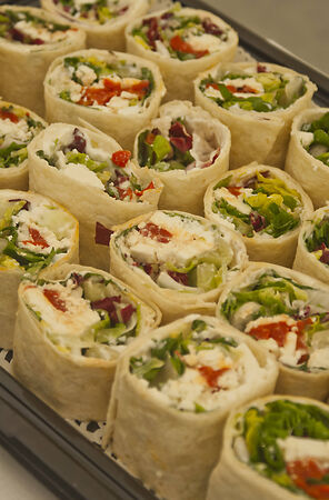 Tray of sliced pitta rolls filled with vegetables and cheeseの写真素材
