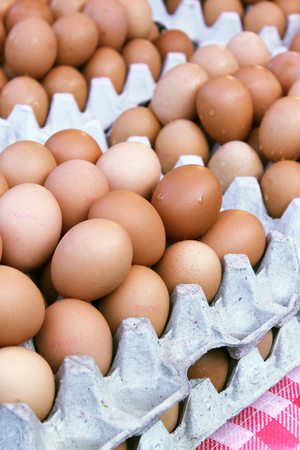 Fresh hicken eggs on sale on carton trays in a marketの写真素材