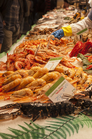 Fishmonger stall in an indoor market with fresh seafood and fishの写真素材
