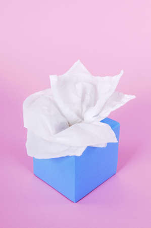 Paper tissues in blank blue box on a pink background.の写真素材
